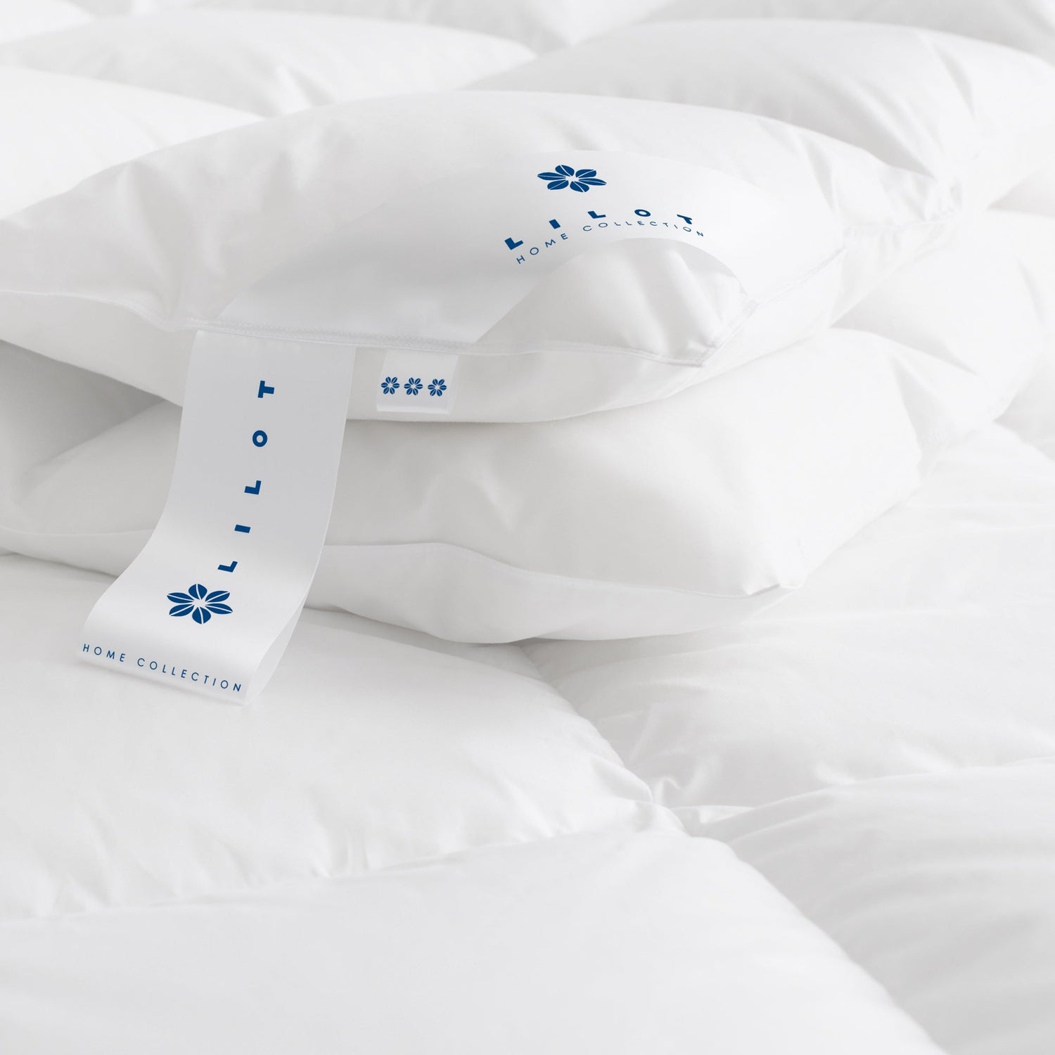 Close-up of the corner of the Lilot Winter (extra-weight, extra-warm) Goose Down Duvet, featuring brand and info labels with a dark-blue logo sign.