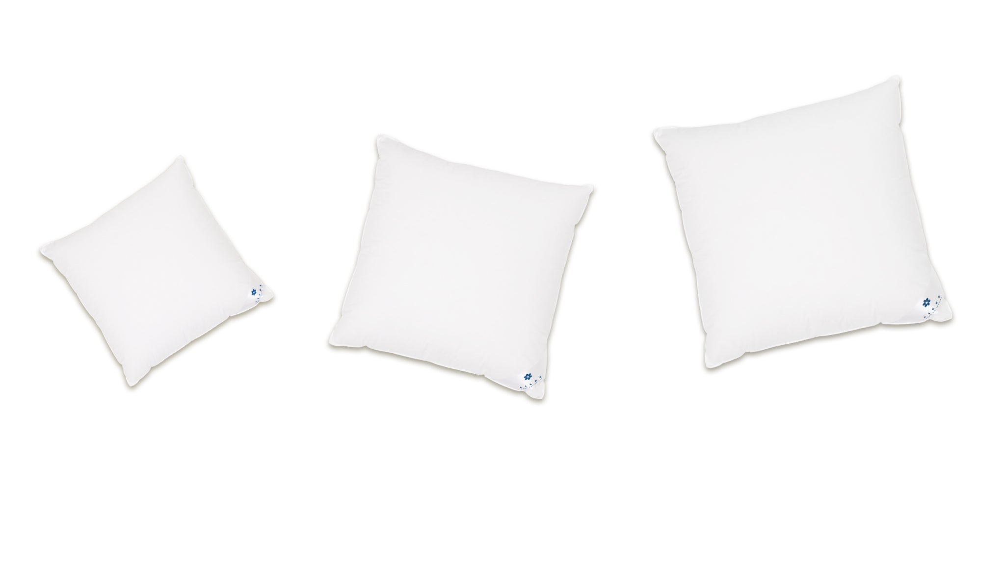 Three Aurora Lilot Pillows are arranged against an elegant white background.