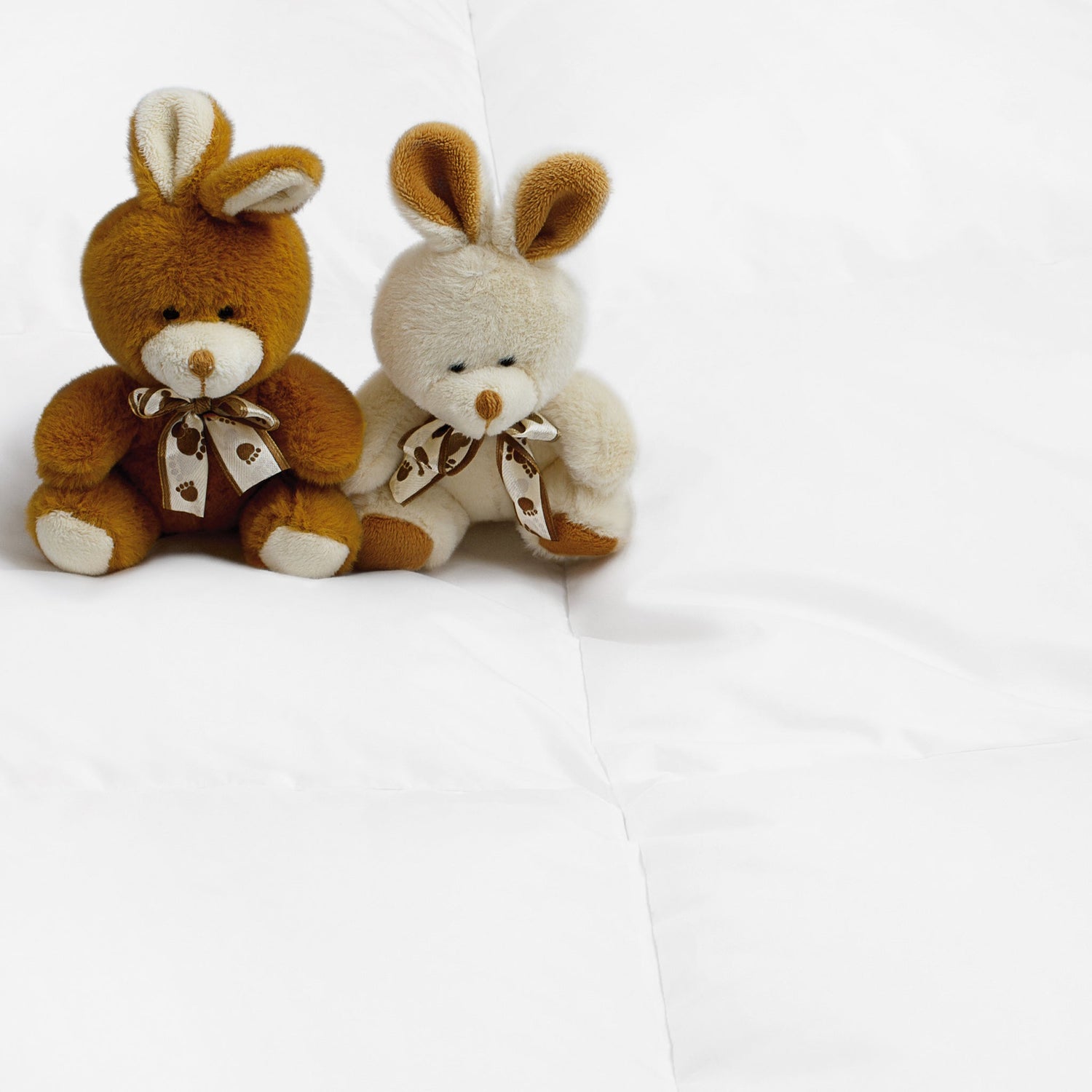 Plush toys arranged on a neatly made bed, adding a touch of whimsy to the elegant Aurora Lilot Kids Duvet.