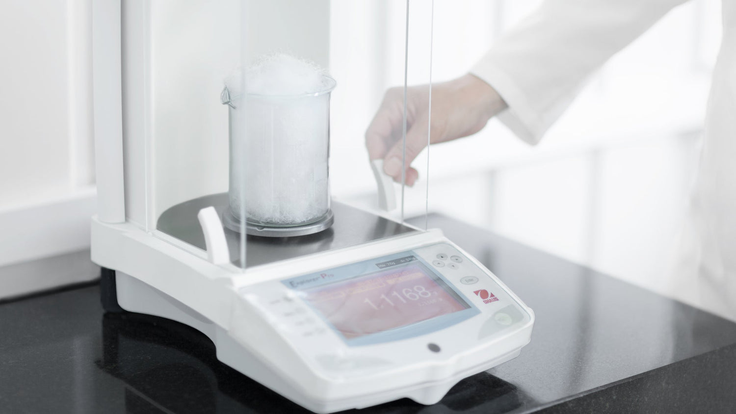 Photo of the process at the Aurora Lilot factory lab: weighing white goose down on precise laboratory scales.