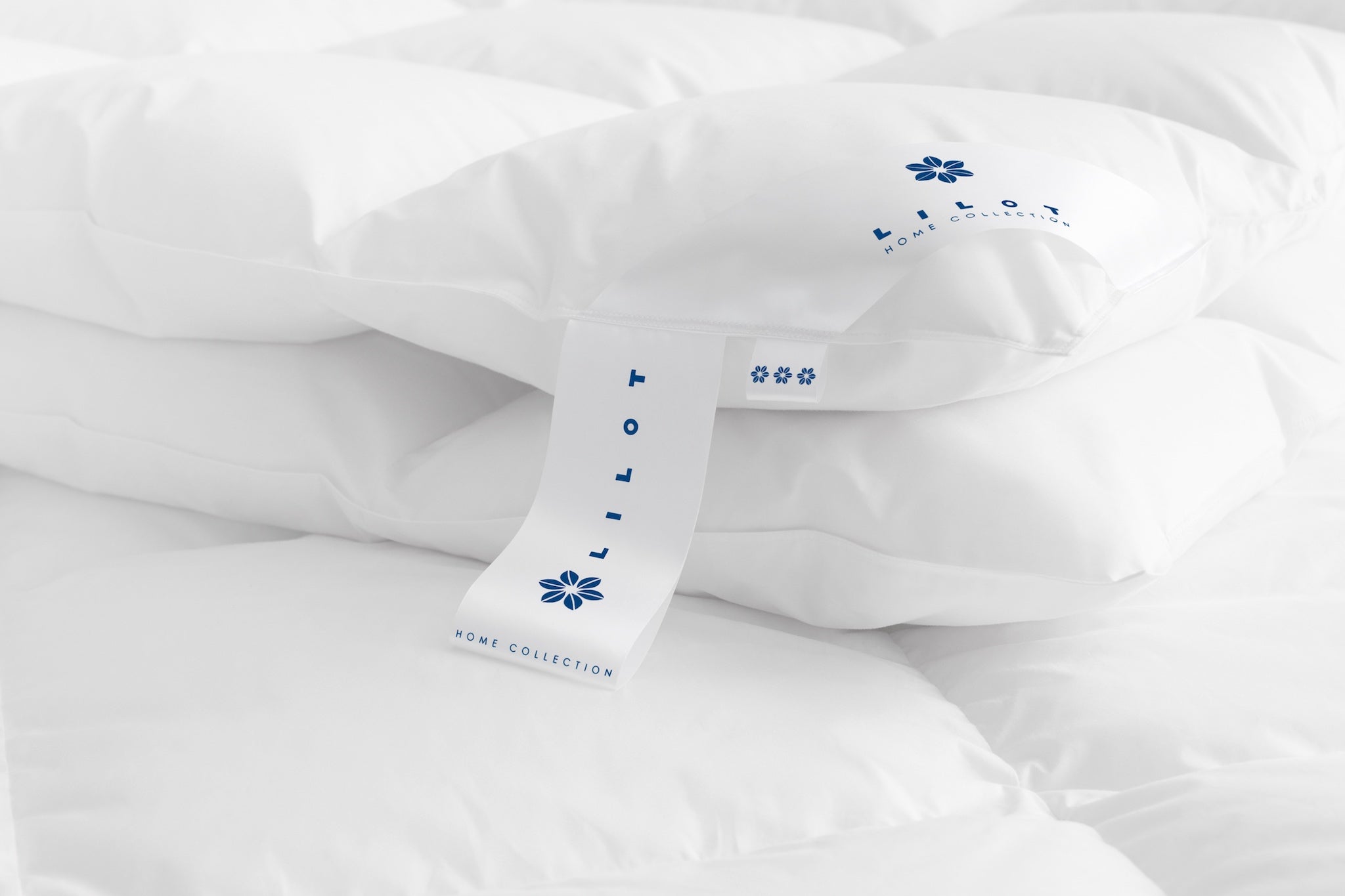 Close-up of the corner of the Lilot Winter (extra-weight, extra-warm) Goose Down Duvet, featuring brand and info labels with a dark-blue logo sign.